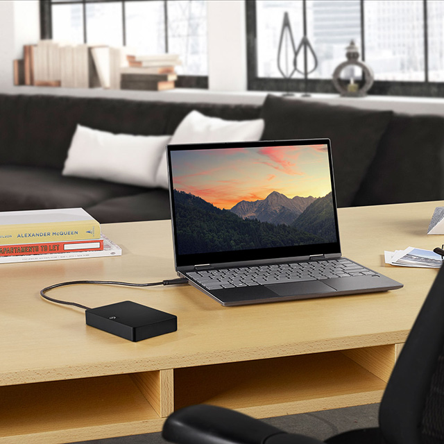 portable SSD drive next to a laptop