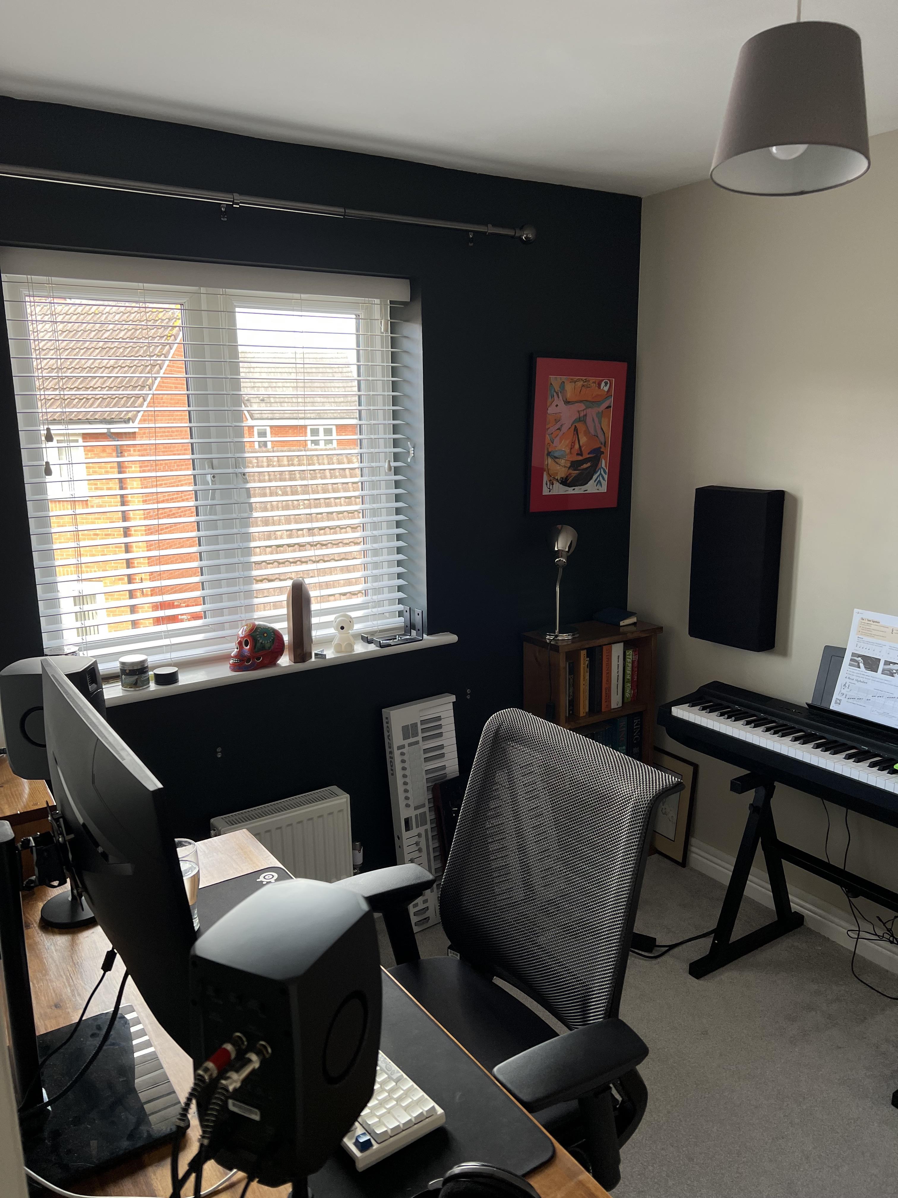 small home studio desk beside a window